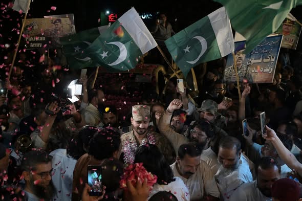 People throw rose petals at army personnel to express solidarity with Pakistan's armed forces in May, 2025. Image via Dawn.